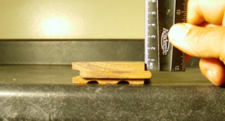 Ruler measures 1/4" of wood above the nails in a traditional solid hardwood flooring type.