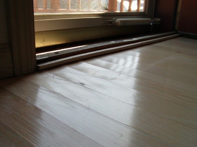 water damaged wood floor just inside an exterior entrance door